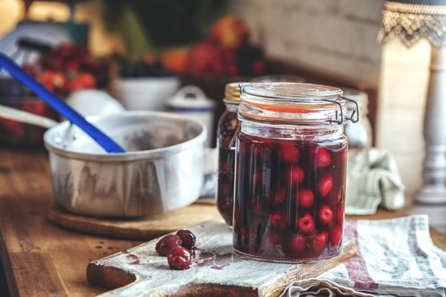 Een pot met kersencompote op een sfeervol gedekte ontbijttafel