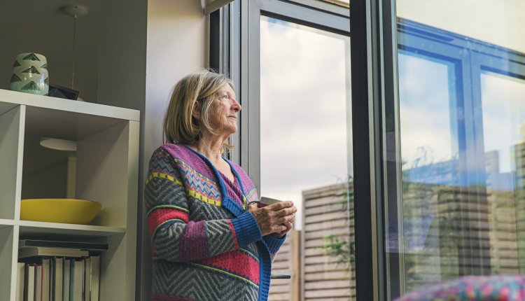 Gas en stroom besparen oudere vrouw kijkt uit het raam