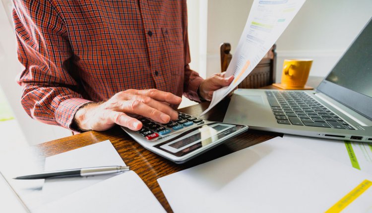 Man achter computer doet zijn administratie