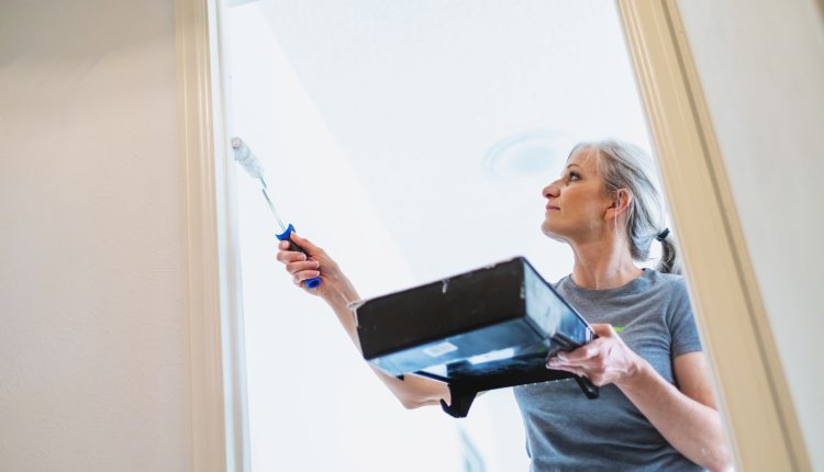 Verbouwing, vrouw is aan het schilderen in huis