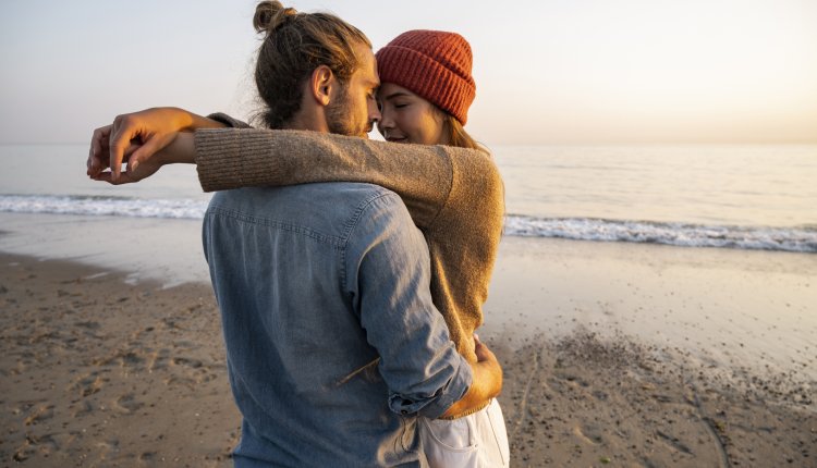 Verliefd jong stel knuffelt op het strand