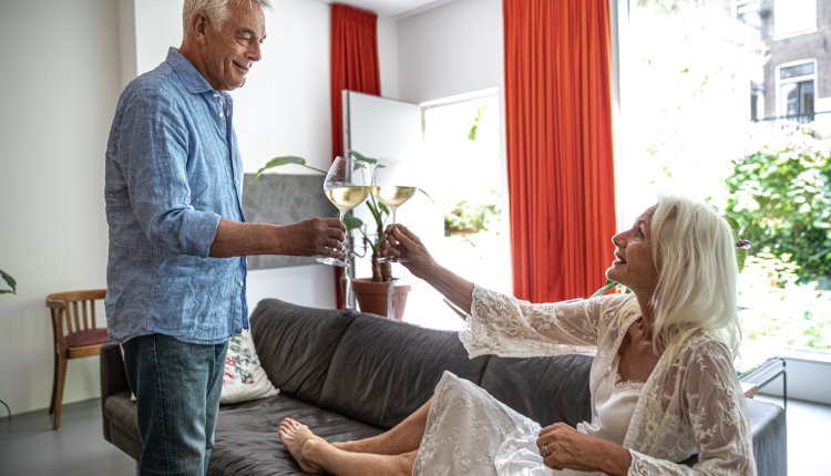 Gepensioneerd koppel toast in nieuw huis