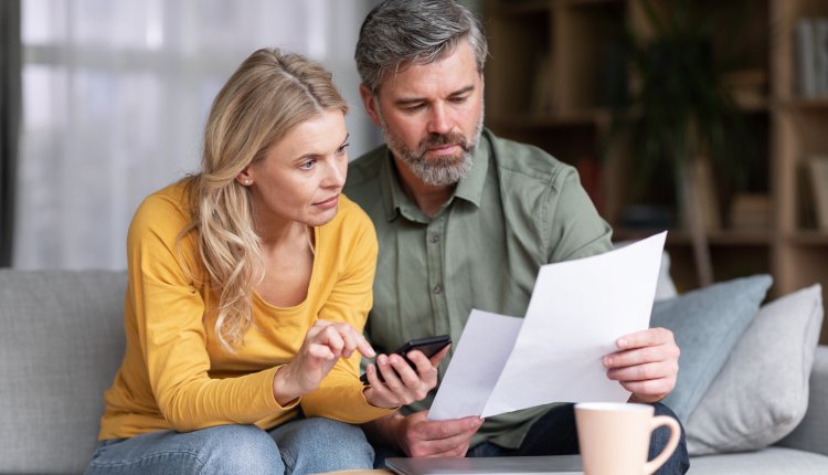 Ouder koppel op de bank met papierenc