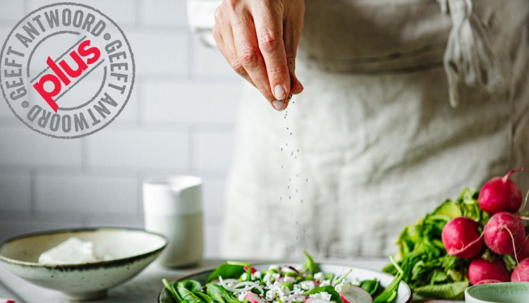 vrouw strooit zout op salade