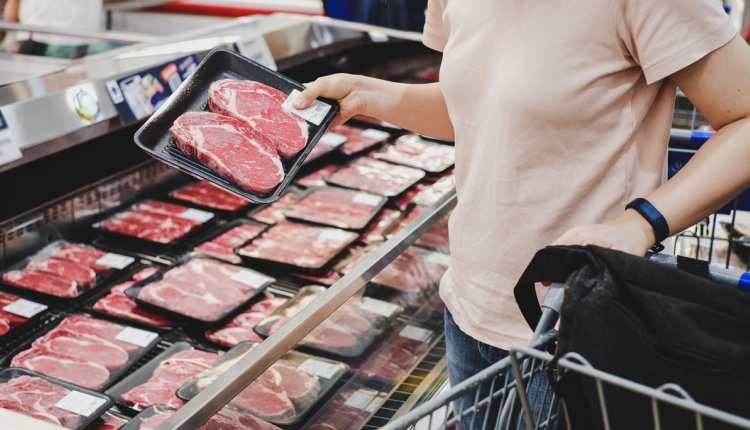 persoon koopt vlees in de supermarkt