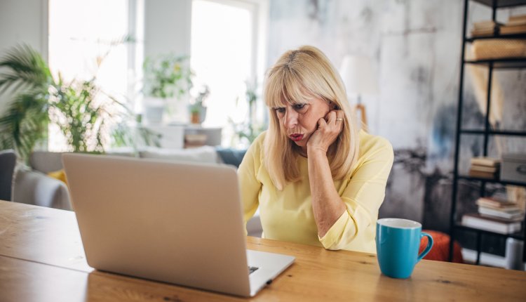 Vrouw kijkt bezorgd op laptop