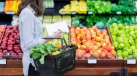 Vrouw op de groente en fruit afdeling in de supermarkt