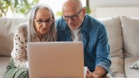 Man en vrouw bestuderen laptop op de bank in de woonkamer