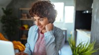 Vrouw in keuken op laptop