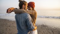 Verliefd jong stel knuffelt op het strand