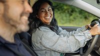 Vrouw achter het stuur met man ernaast in de auto