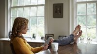 Vrouw zit met haar tablet achter haar bureau