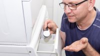 Wasmachine man doet poeder in vakje