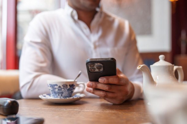 man aan tafel gebruikt iPhone